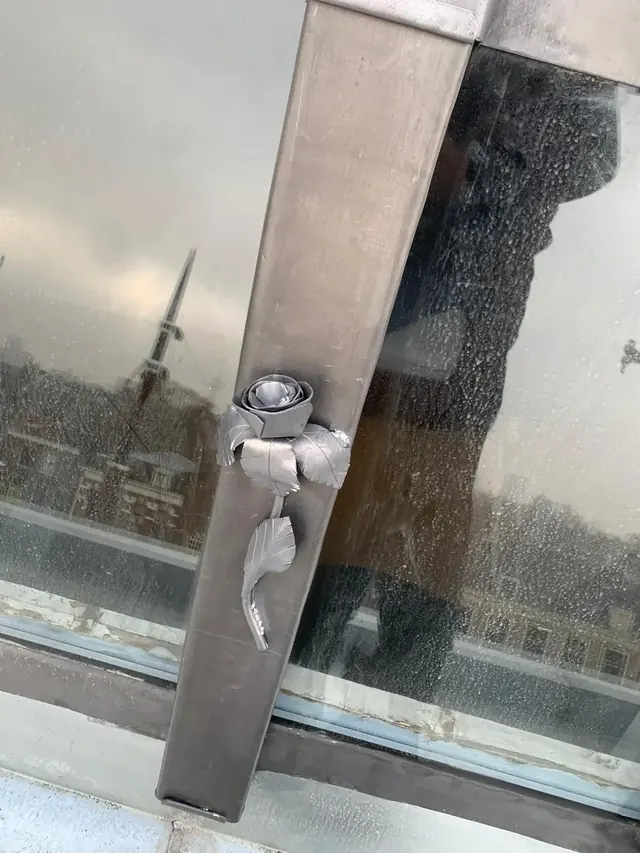 Metalen roos bij een dakraam — Een uitgewerkt metalen ornament op de omlijsting van een dakraam.