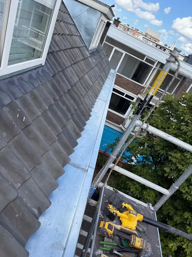 Goot langs een pannendak — De metalen goot volgt de onderzijde van het schuine dakvlak.